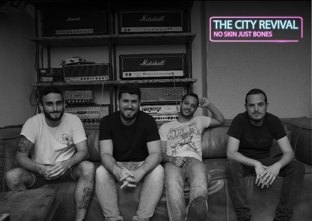 The City Revival on a couch in front of a wall of amps